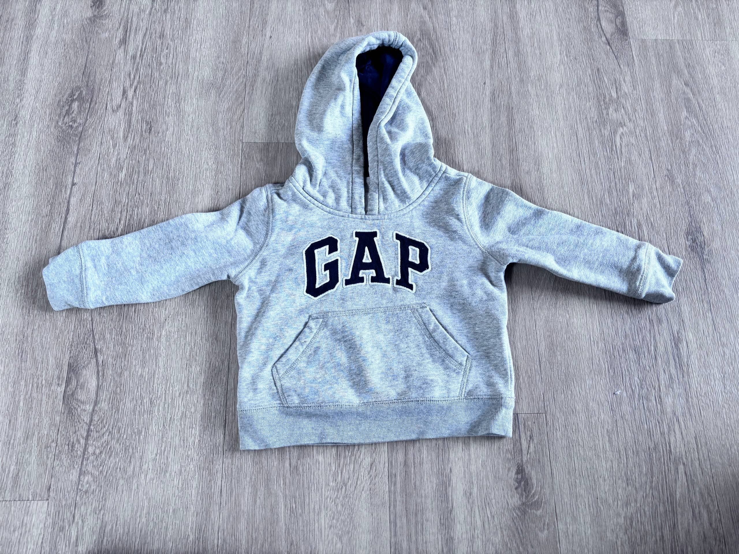 Sivi pulover s kapuco in žepom